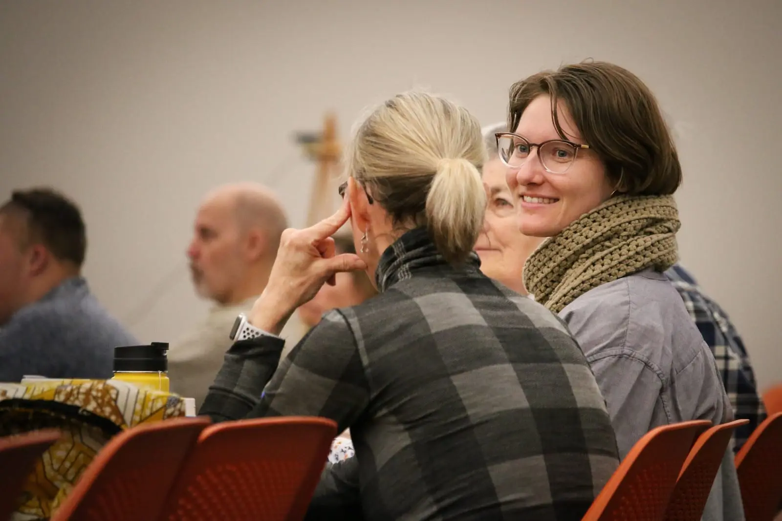 Two friends smiling as they listen during a conversation