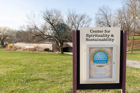 A sign for the Center for Spirituality and Sustainability on a green lawn